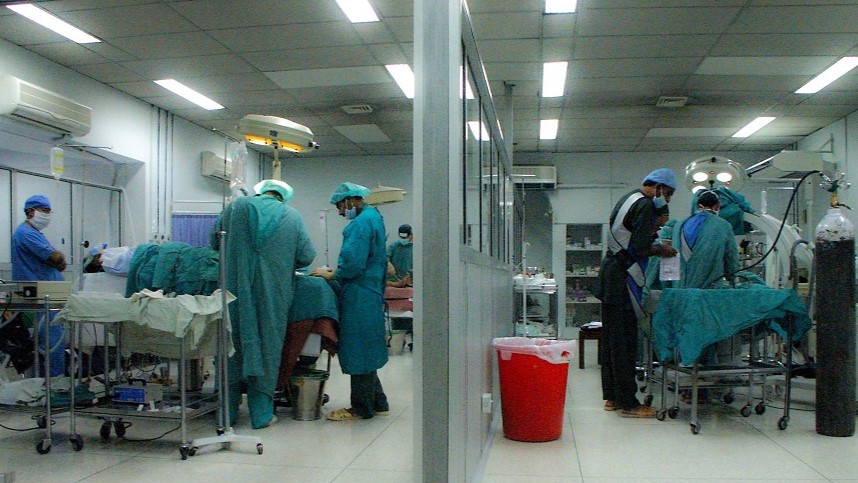 Two side by side operating theatres with medical staff operating on patients in Pakistan 2005
